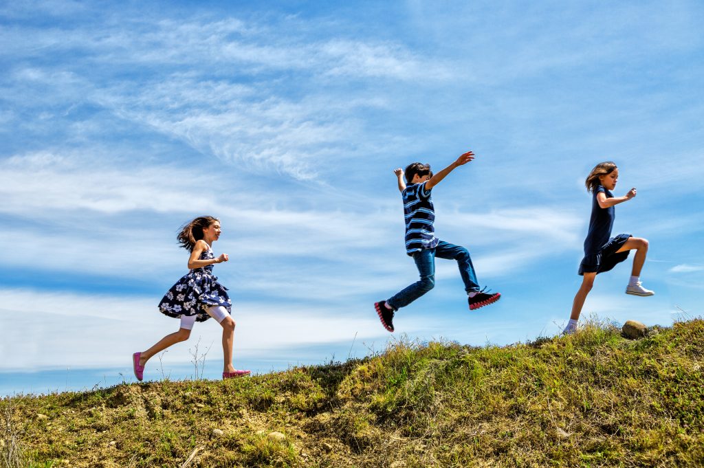 An image pf Children Playing on a hill.