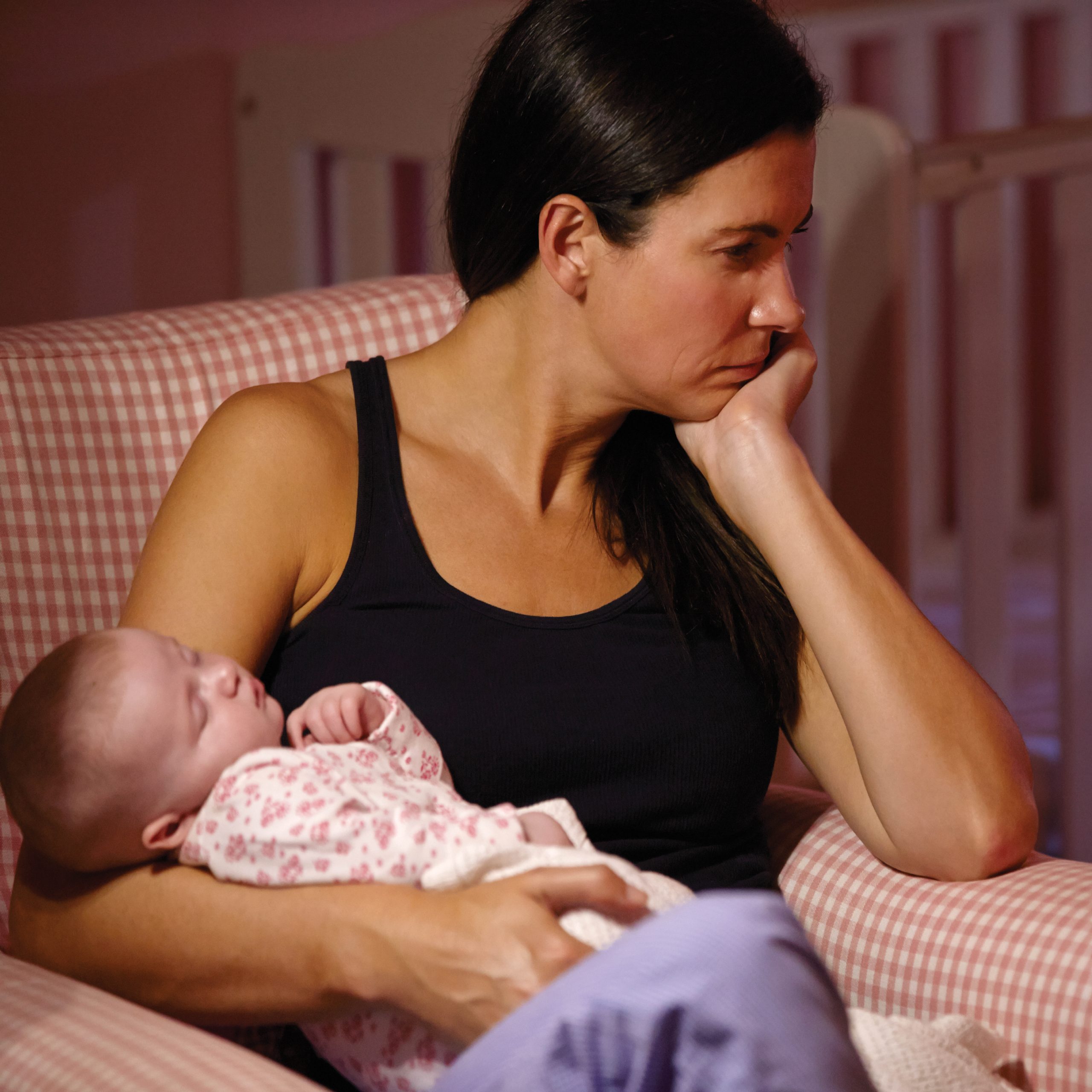 Mother holding baby and looking depressed