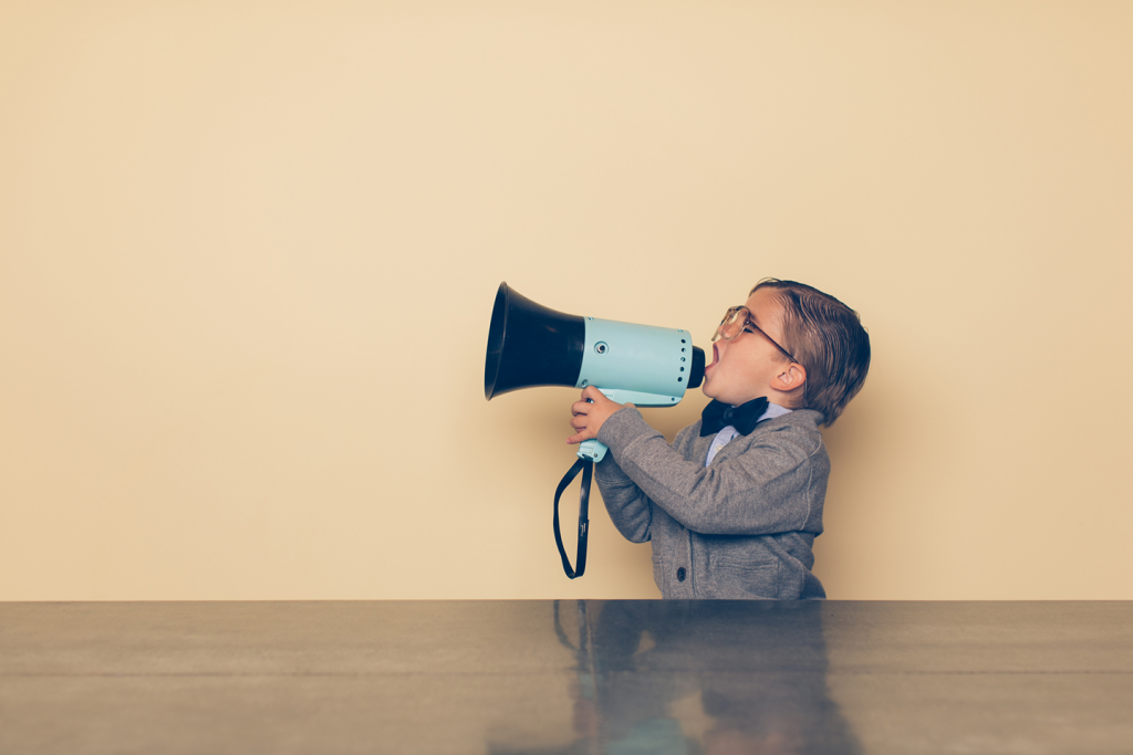 An image of a boy speaking or calling using a Megaphone