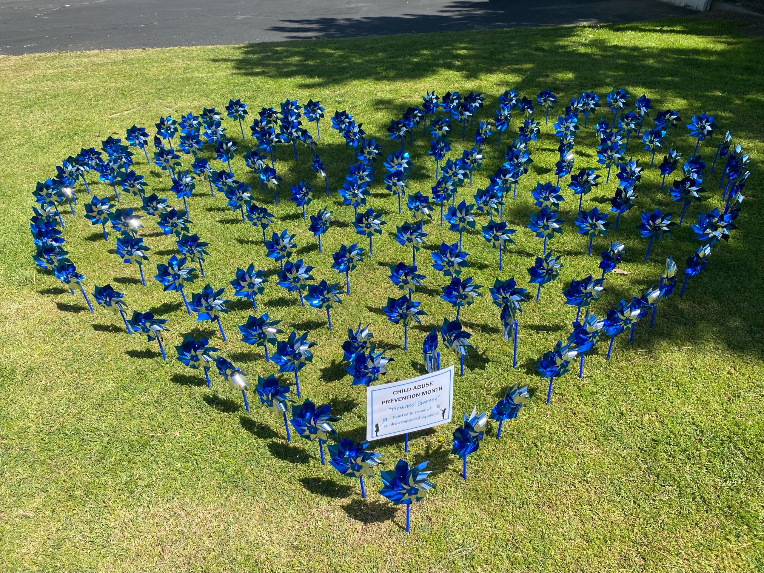 A heart shaped group of pinwheels on grass created for child abuse prevention month.